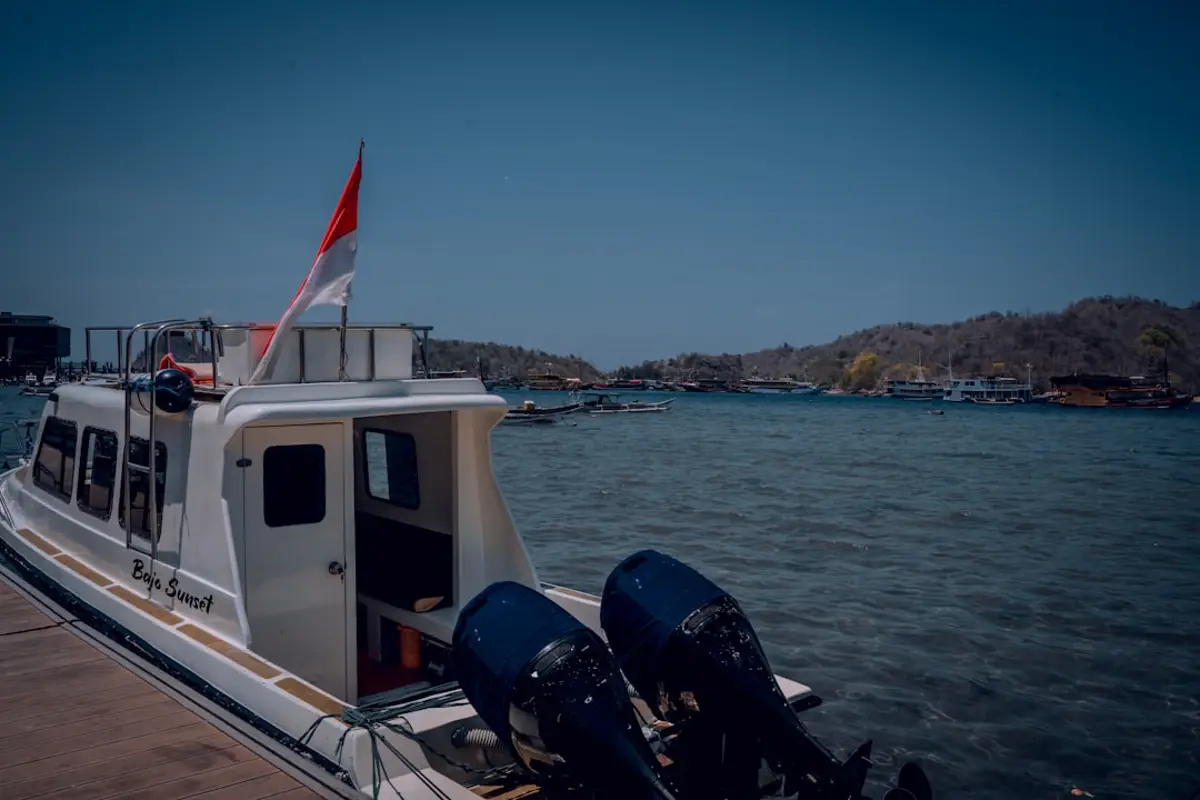 a white boat with a red and white flag on it